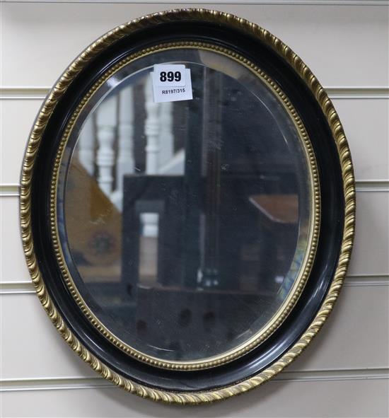 A Victorian oval giltwood and ebonised framed wall mirror 41 x 35cm